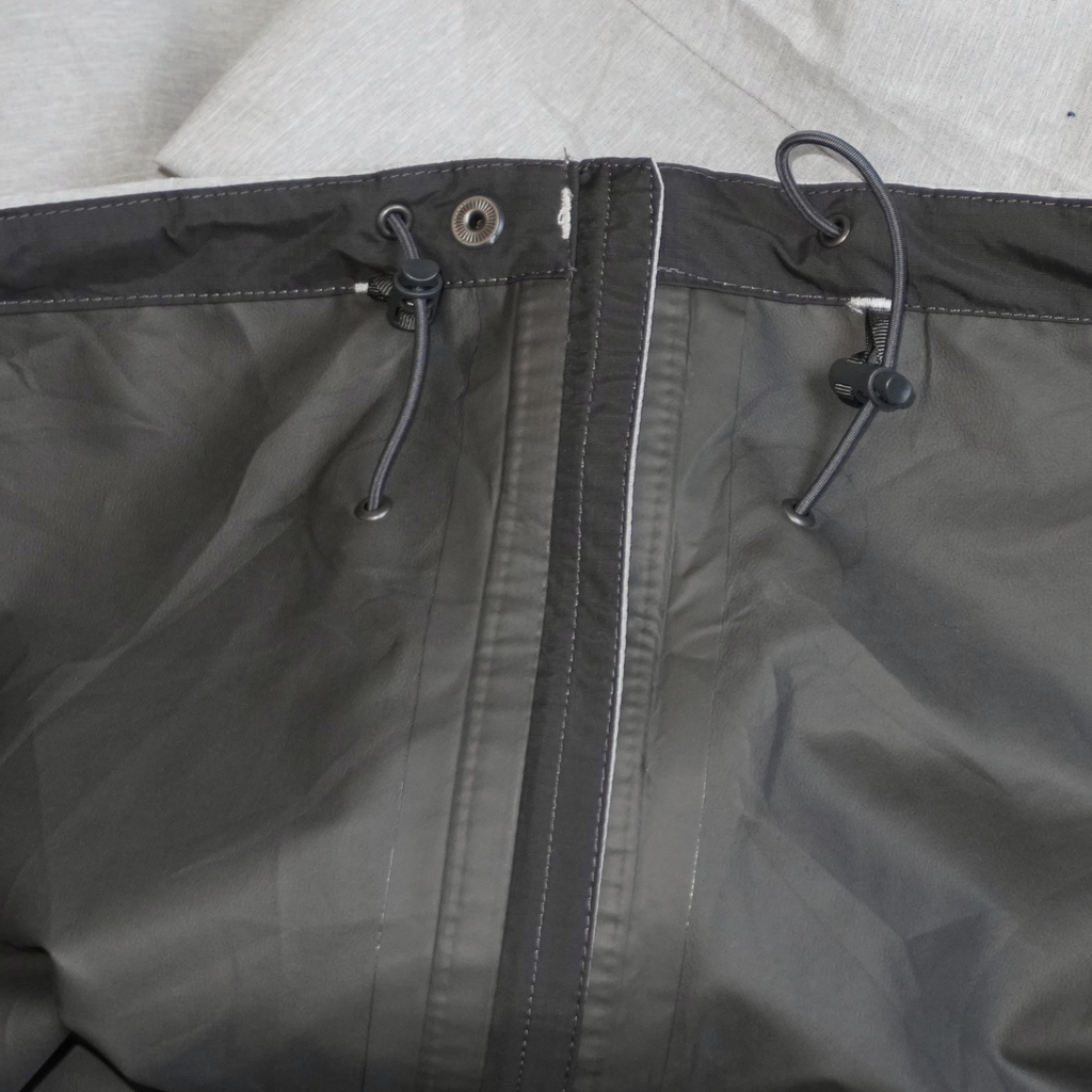 Detalle del gorro ajustable con cordones de la chamarra impermeable gris The North Face Dryzzle de Mi tienda