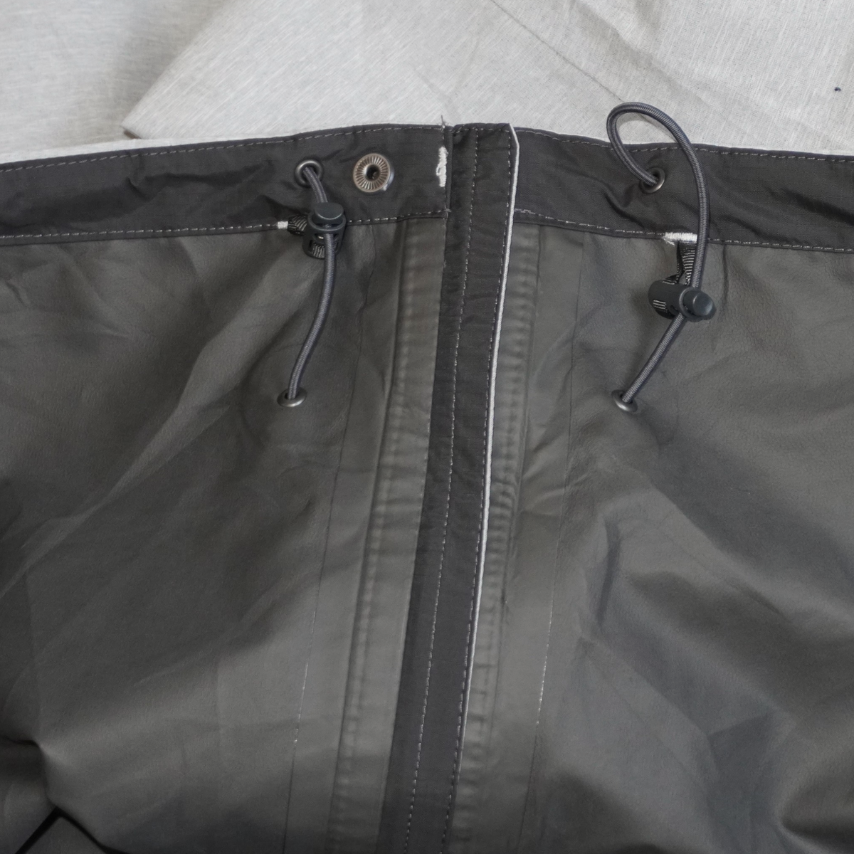 Detalle del gorro ajustable con cordones de la chamarra impermeable gris The North Face Dryzzle de Mi tienda