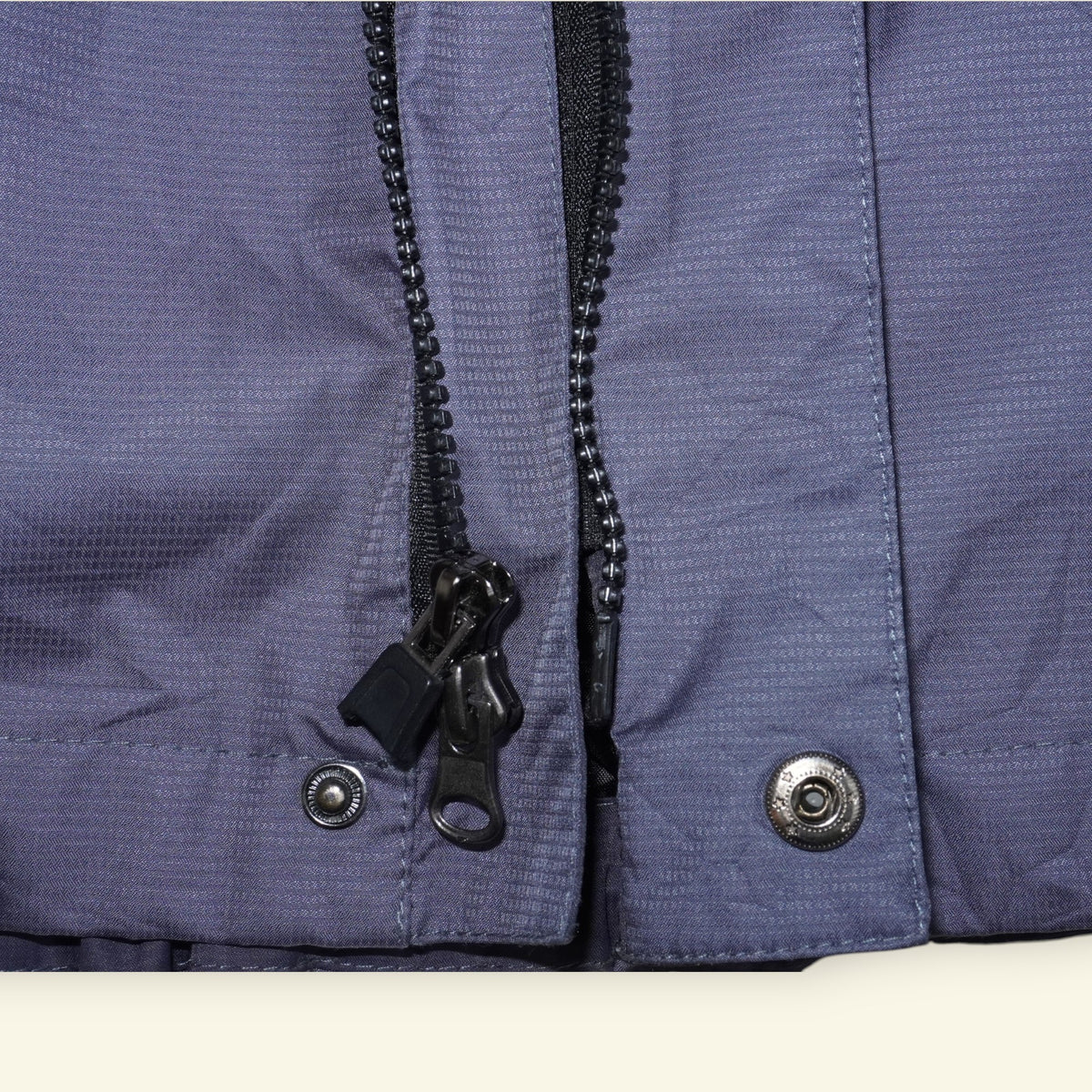 Detalle de cierre y botones a presión en chamarra vintage Mi tienda The North Face Summit Series gris con Gore-Tex