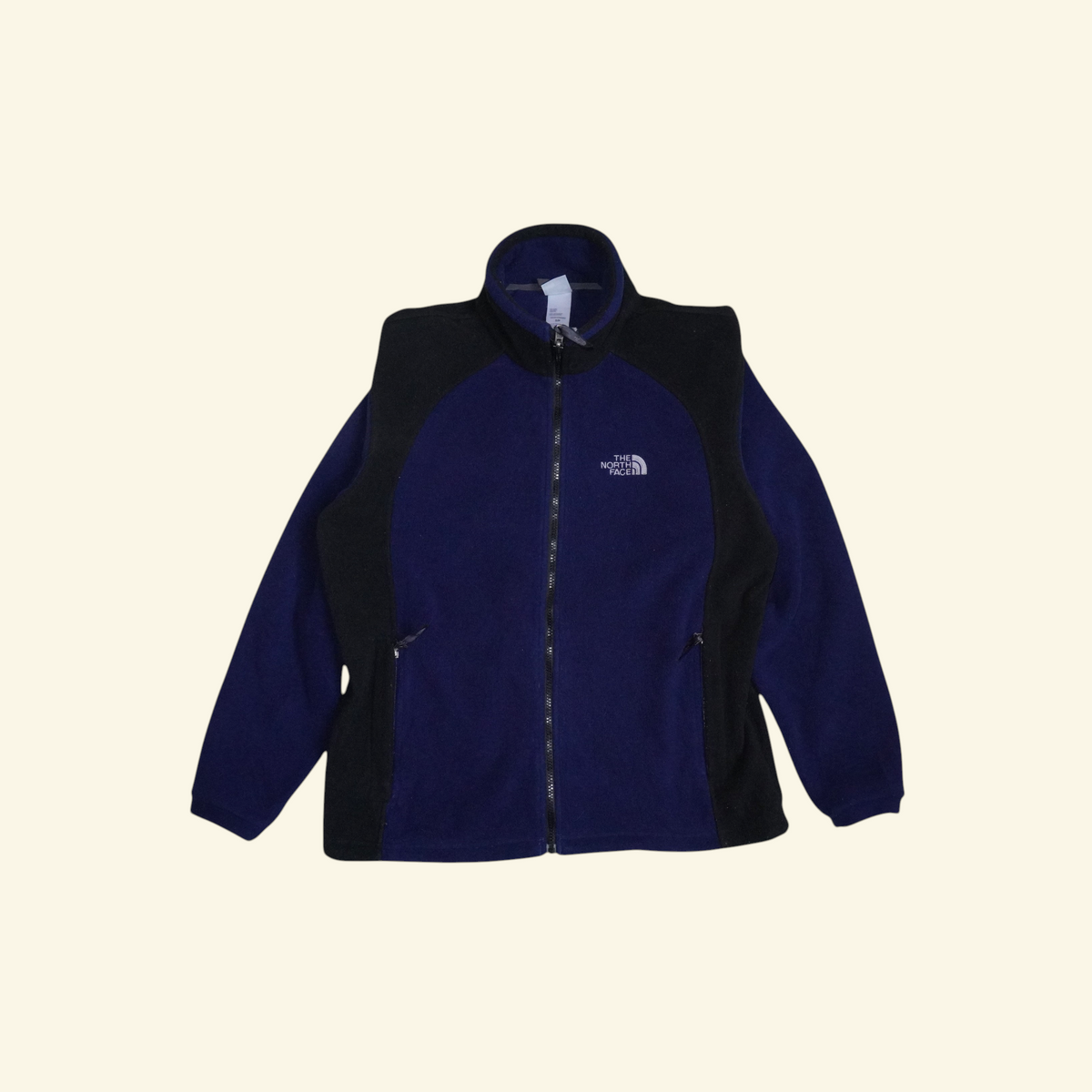Chamarra de forro polar Mi tienda The North Face en azul marino y negro con diseño colorblock y cierre frontal.
