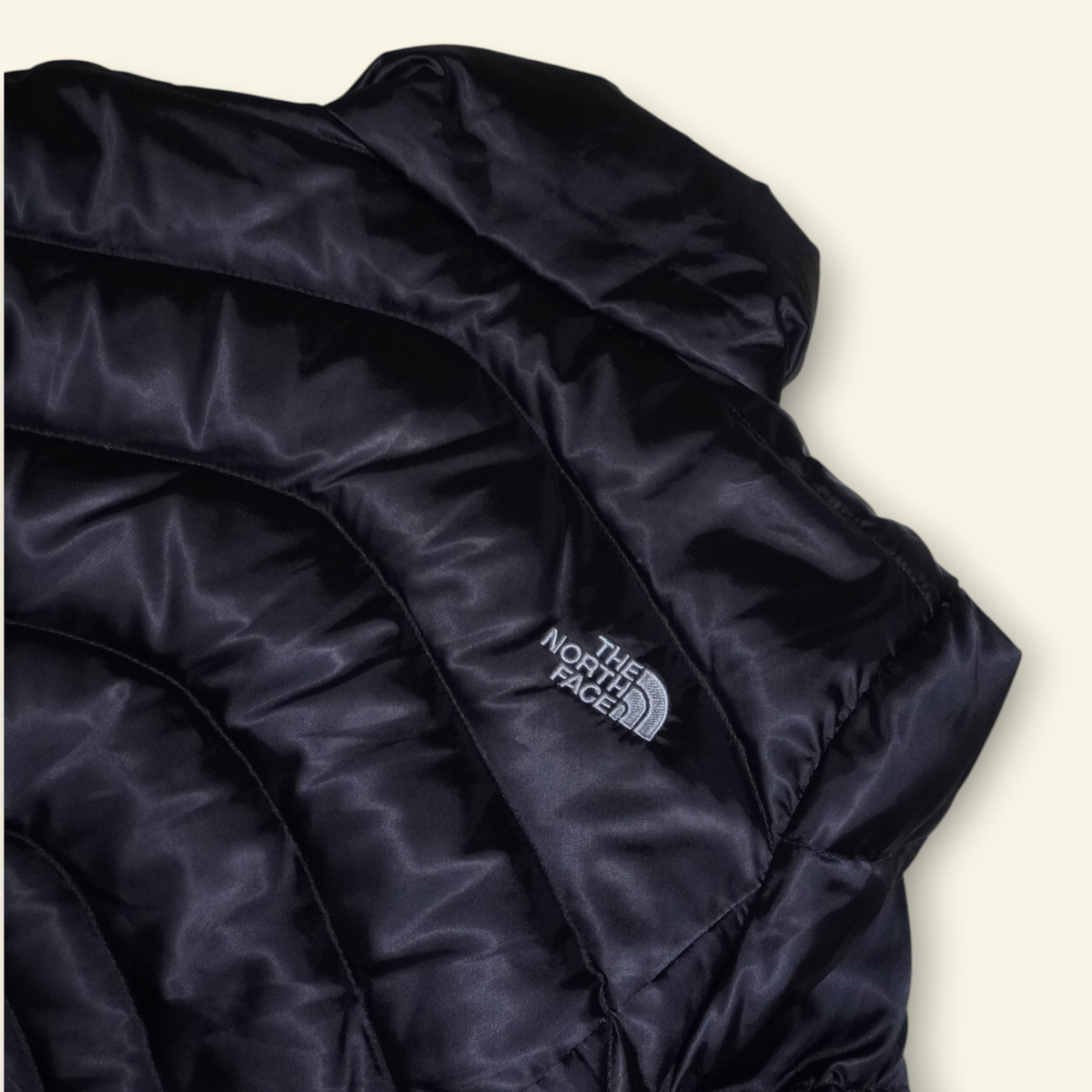 Chamarra puffer negra The North Face Aconcagua de Mi tienda con acolchado horizontal y logo bordado en el pecho.