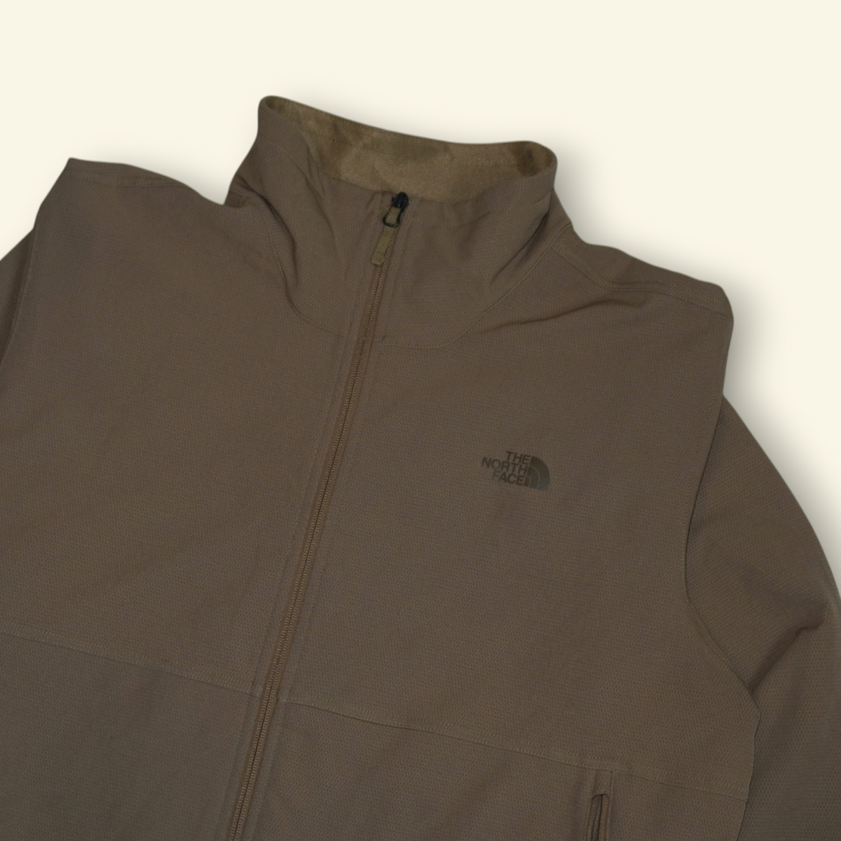 Chamarra The North Face color caqui con cierre completo y cuello alto, disponible en Mi tienda