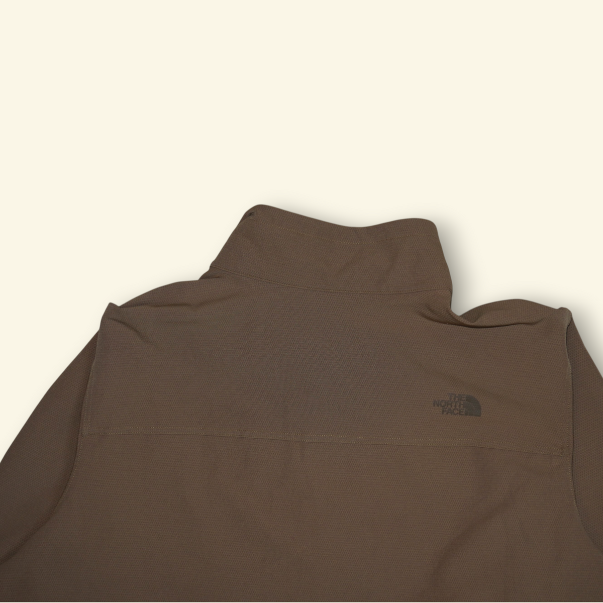 Chamarra The North Face Track color khaki con cuello alto y logo bordado, disponible en Mi tienda