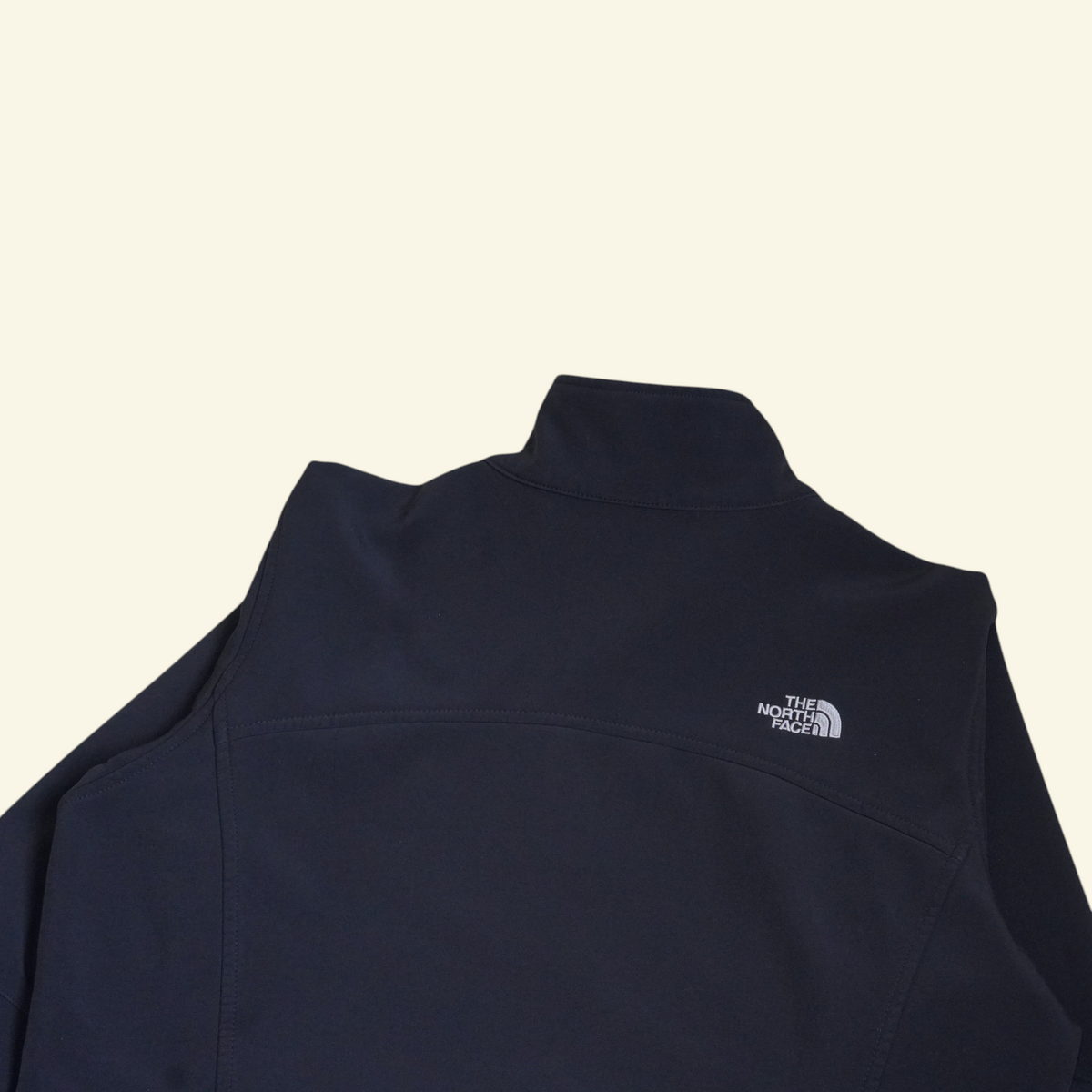 Chaqueta softshell negra The North Face de Mi tienda con logo bordado en la espalda, ideal para clima frío.
