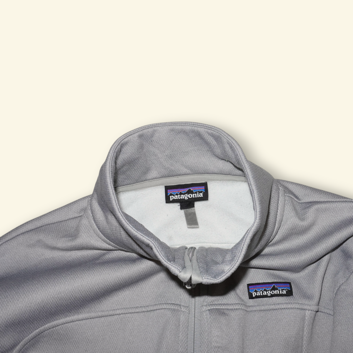Chaqueta Patagonia Ukiah gris de poliéster con cuello alto y cierre frontal, estilo urbano y técnico.