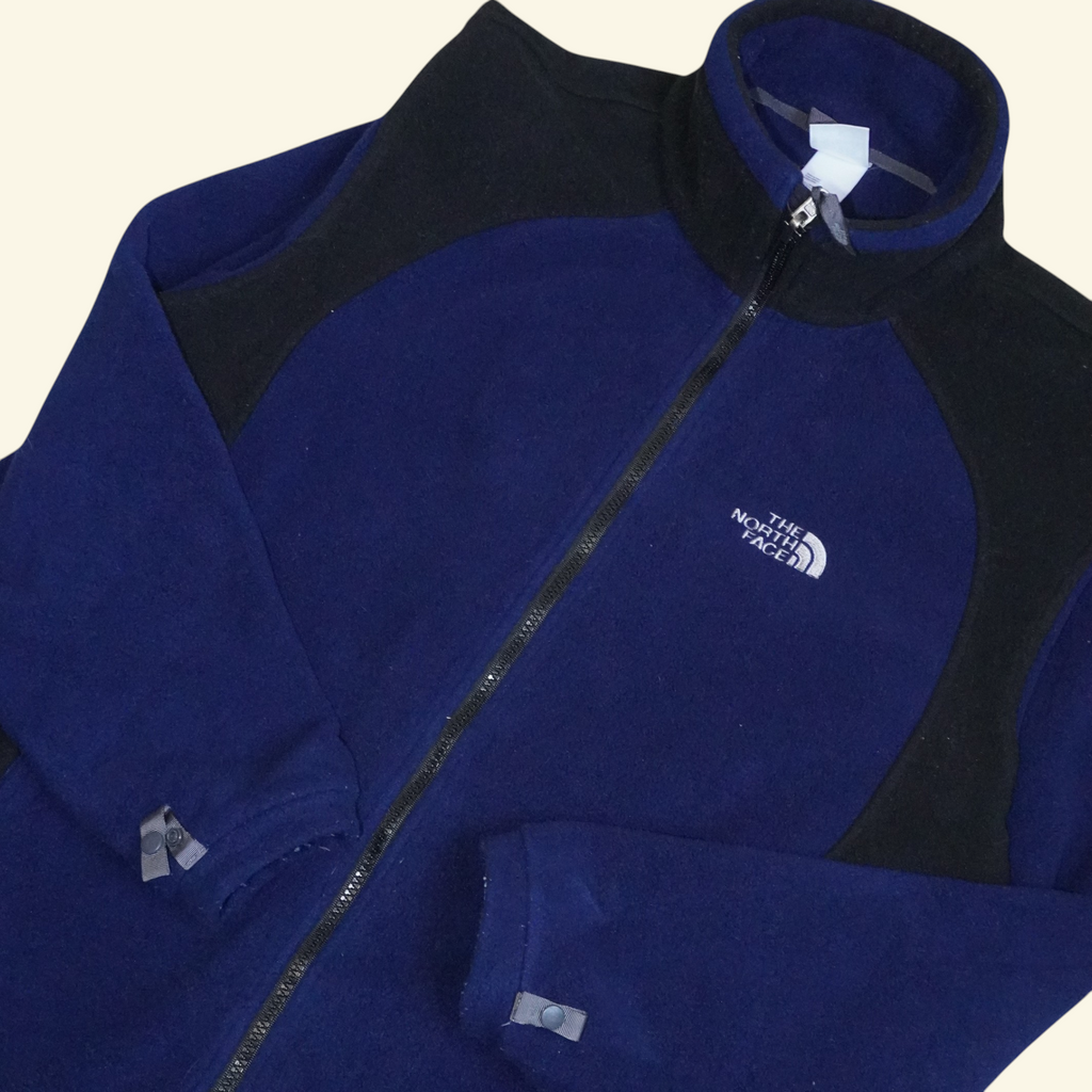Chamarra de forro polar Mi tienda The North Face en azul marino y negro con diseño colorblock y cierre frontal.