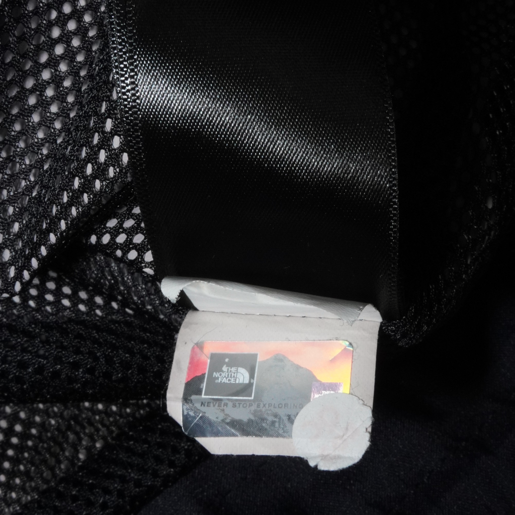 Etiqueta de autenticidad holográfica en el interior de una chamarra impermeable negra Mi tienda The North Face DryVent